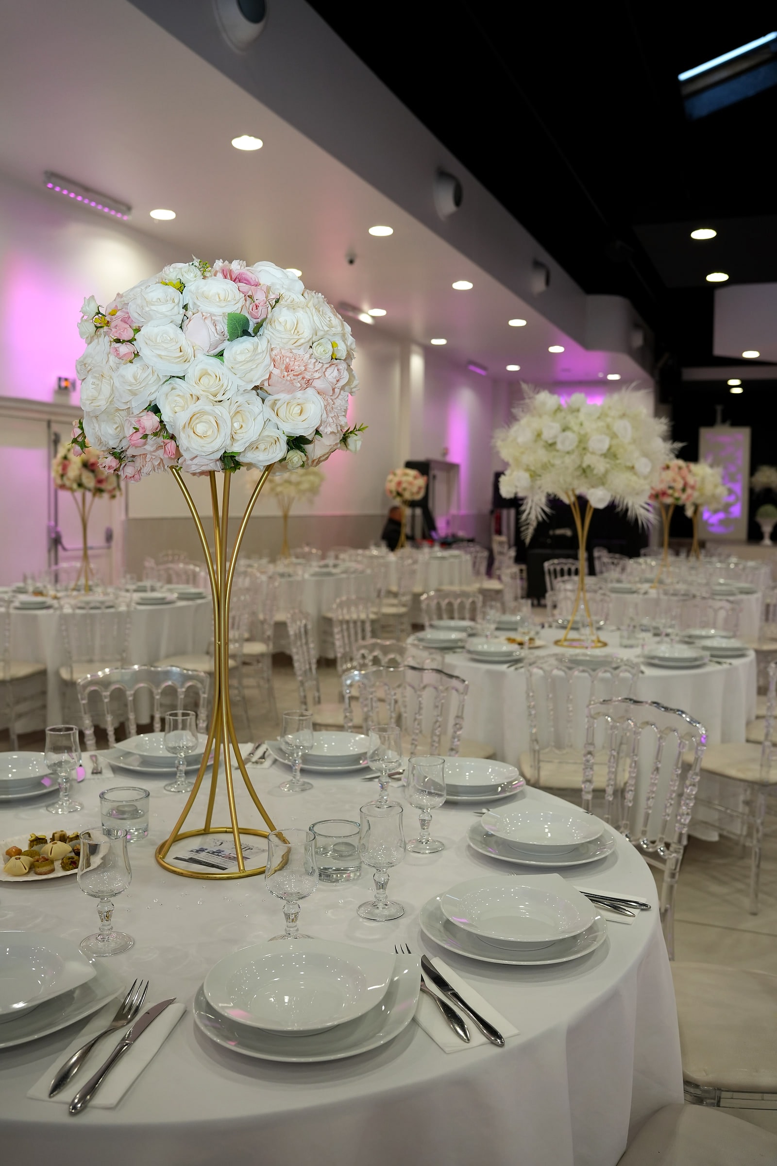 Une table ronde dressée sous un bouquet blanc