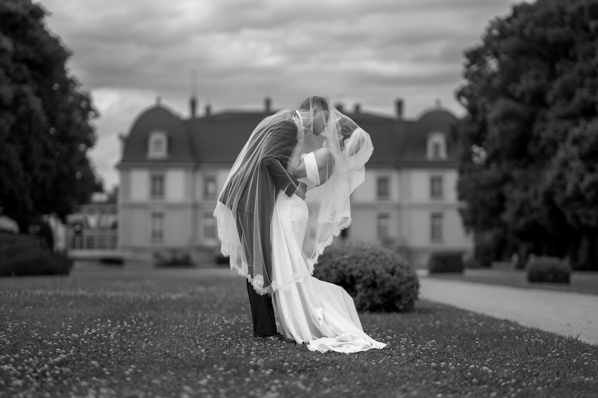 Le baiser au château — Le voile dans le vent, noir et blanc — photographie mariage & événement par UNPOSD